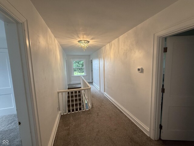 2607 N Henderson Rd, Rushville, IN 46173 - hallway featuring carpet, an upstairs landing, and a chandelier