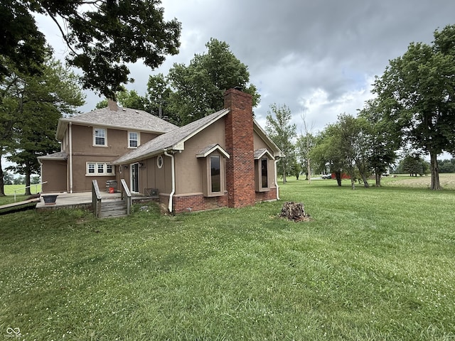 2607 N Henderson Rd, Rushville, IN 46173 - view of side of home with a chimney, a yard, stucco siding, and brick siding