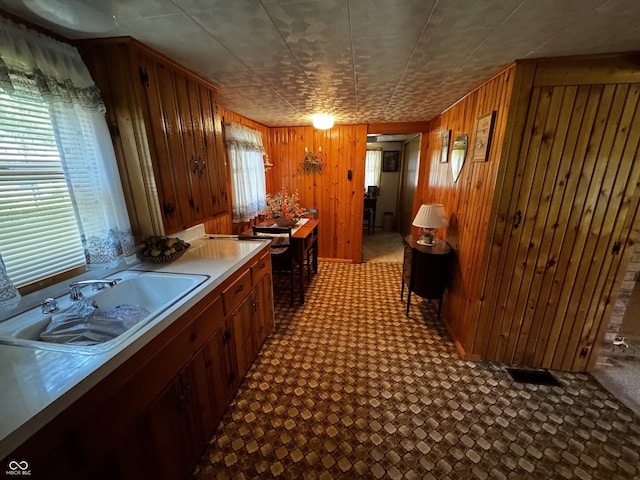 8664 S Nash Dr, Nineveh, IN 46164 - kitchen featuring light countertops, wooden walls, brown cabinets, and dark flooring