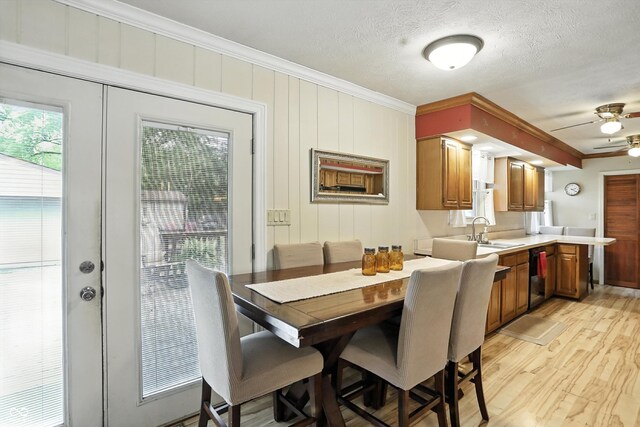 7113 Chandler Dr, Indianapolis, IN 46217 - dining space featuring ornamental molding, ceiling fan, light wood finished floors, and a textured ceiling