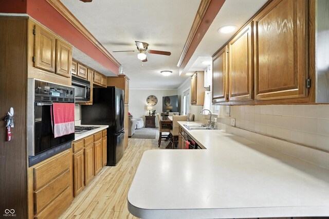 7113 Chandler Dr, Indianapolis, IN 46217 - kitchen with black appliances, crown molding, ceiling fan, light wood-style flooring, and backsplash