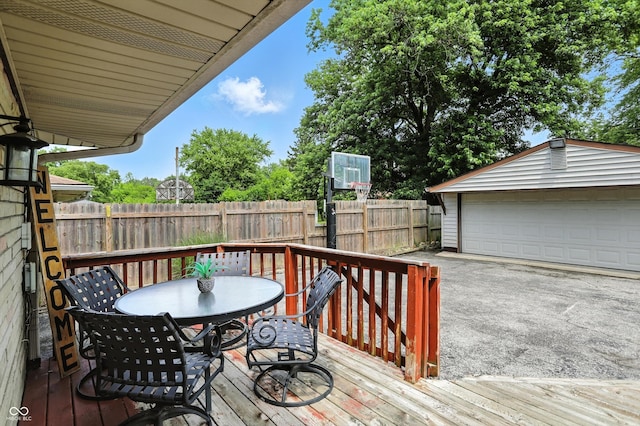 7113 Chandler Dr, Indianapolis, IN 46217 - deck featuring outdoor dining space, a detached garage, and an outdoor structure