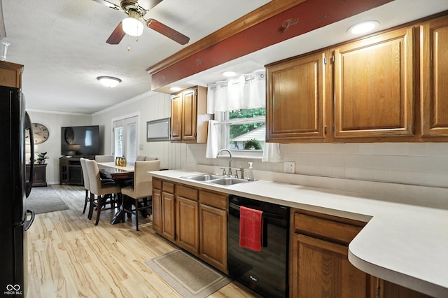 7113 Chandler Dr, Indianapolis, IN 46217 - kitchen featuring black appliances, crown molding, plenty of natural light, light wood-style floors, and light countertops