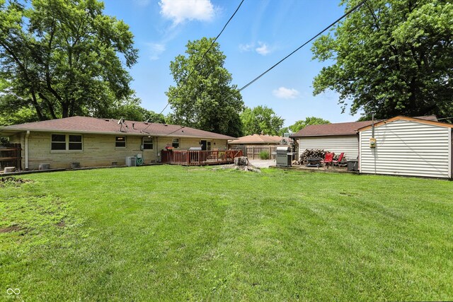7113 Chandler Dr, Indianapolis, IN 46217 - view of grassy yard featuring a wooden deck and a shed