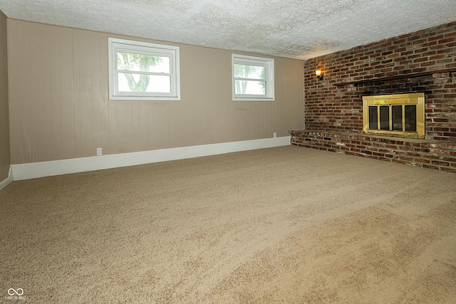 1217 S Post Rd, Indianapolis, IN 46239 - unfurnished living room featuring a textured ceiling, healthy amount of natural light, carpet floors, and a brick fireplace