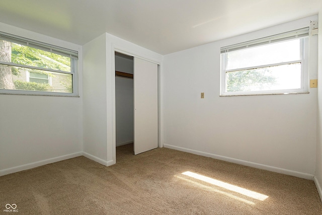 1217 S Post Rd, Indianapolis, IN 46239 - unfurnished bedroom featuring light carpet, multiple windows, and a closet