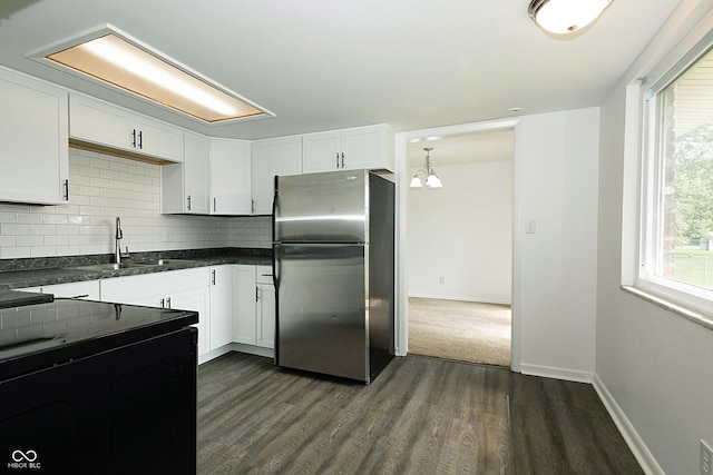 1217 S Post Rd, Indianapolis, IN 46239 - kitchen featuring freestanding refrigerator, dark wood finished floors, backsplash, dark countertops, and white cabinetry