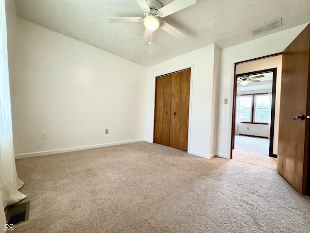100 Justin Dr, Mooresville, IN 46158 - unfurnished bedroom with a textured ceiling, light carpet, a closet, and ceiling fan