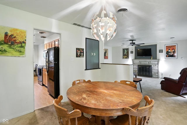 4340 Ashbourne Ln, Indianapolis, IN 46226 - dining room featuring light colored carpet, a fireplace, a chandelier, and ceiling fan