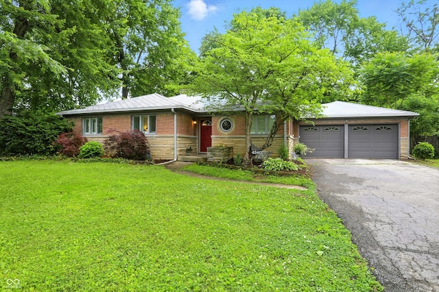 4340 Ashbourne Ln, Indianapolis, IN 46226 - ranch-style house with asphalt driveway, a front lawn, an attached garage, stone siding, and brick siding