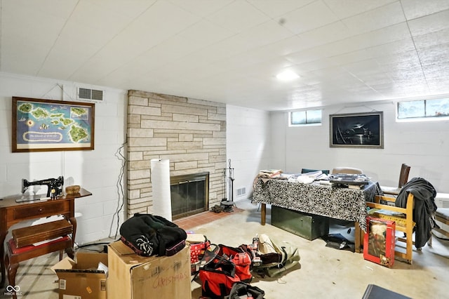 4340 Ashbourne Ln, Indianapolis, IN 46226 - living room with a stone fireplace, plenty of natural light, concrete block wall, and concrete floors