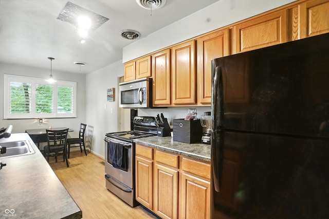 4340 Ashbourne Ln, Indianapolis, IN 46226 - kitchen featuring appliances with stainless steel finishes, light wood finished floors, pendant lighting, and brown cabinets