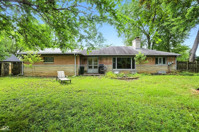 4340 Ashbourne Ln, Indianapolis, IN 46226 - rear view of house featuring a chimney, stone siding, and roof with shingles