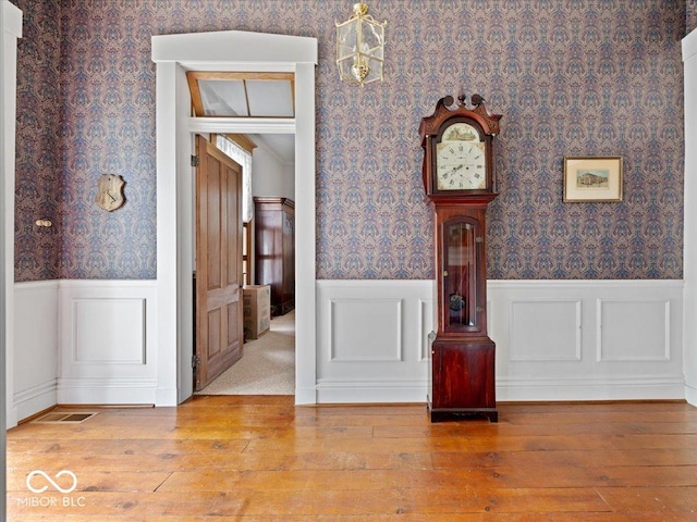 228 W Washington St, Shelbyville, IN 46176 - unfurnished room with wallpapered walls, hardwood / wood-style floors, and wainscoting
