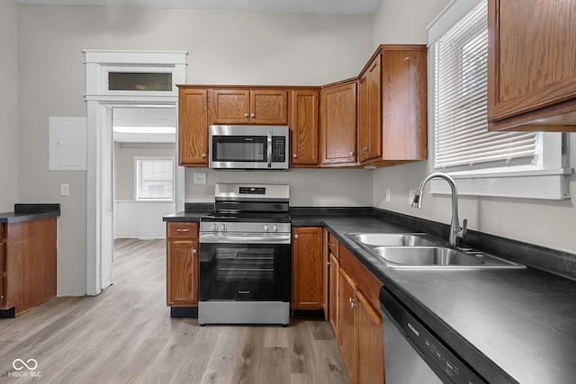 1310 California St, Columbus, IN 47201 - kitchen with appliances with stainless steel finishes, brown cabinets, dark countertops, and light wood-style floors