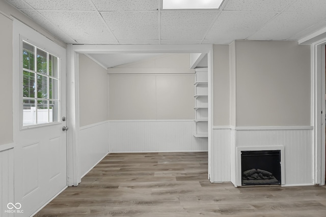 1310 California St, Columbus, IN 47201 - unfurnished living room featuring wainscoting, wood finished floors, lofted ceiling, and a fireplace