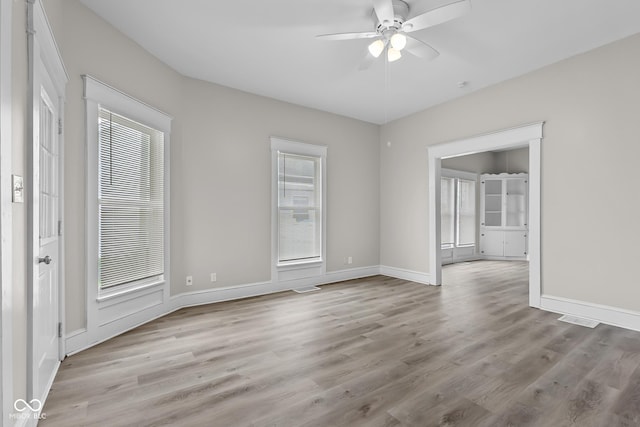 1310 California St, Columbus, IN 47201 - empty room featuring plenty of natural light, a ceiling fan, and wood finished floors