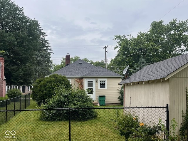 111 S Jefferson St, Brownsburg, IN 46112 - back of property featuring a chimney, a shingled roof, and an outdoor structure