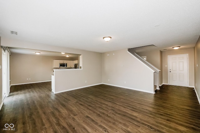 8310 Becks Mill Ln, Indianapolis, IN 46113 - unfurnished living room with dark wood-style flooring and stairs
