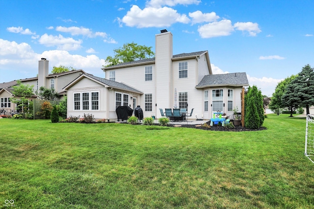9653 Cypress Way, Carmel, IN 46032 - rear view of house with a patio, a lawn, and a chimney