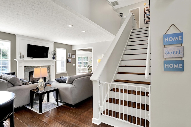 9653 Cypress Way, Carmel, IN 46032 - living room with dark wood-style flooring, a high end fireplace, stairway, and a textured ceiling