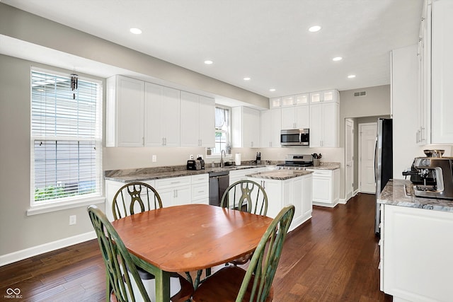 9653 Cypress Way, Carmel, IN 46032 - kitchen featuring appliances with stainless steel finishes, dark wood-style flooring, white cabinets, a kitchen island, and recessed lighting