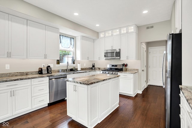 9653 Cypress Way, Carmel, IN 46032 - kitchen featuring appliances with stainless steel finishes, dark wood-style flooring, a center island, glass insert cabinets, and white cabinets