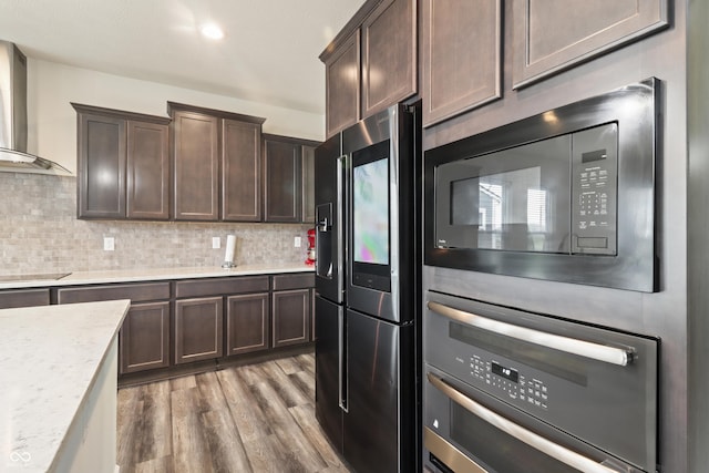 10811 Wild Orchard Ln, Indianapolis, IN 46239 - kitchen with black appliances, wall chimney exhaust hood, dark brown cabinets, wood finished floors, and tasteful backsplash