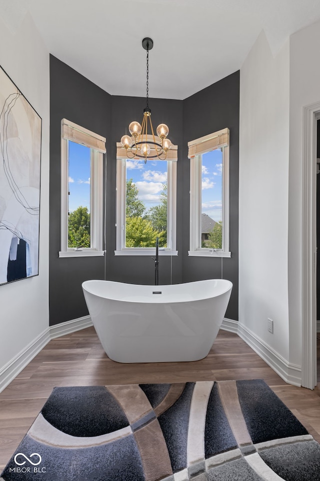 4396 W Eagle Trce, New Palestine, IN 46163 - full bathroom with healthy amount of natural light, a freestanding bath, wood finished floors, and a chandelier