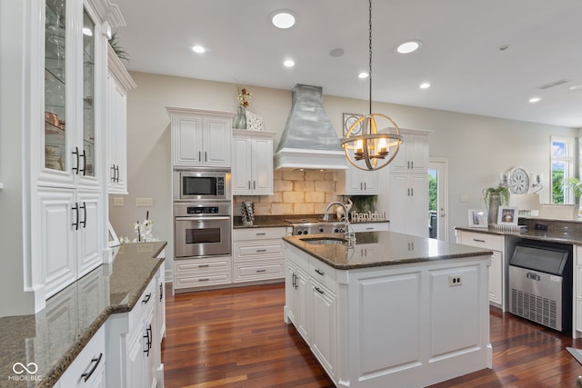4396 W Eagle Trce, New Palestine, IN 46163 - kitchen featuring appliances with stainless steel finishes, custom exhaust hood, a chandelier, backsplash, and dark wood-style floors