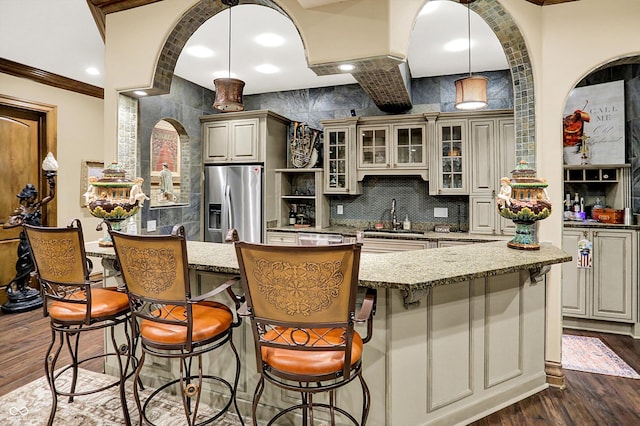 11557 Willow Springs Dr, Zionsville, IN 46077 - kitchen with stainless steel fridge with ice dispenser, dark wood-type flooring, a kitchen bar, glass insert cabinets, and ornamental molding