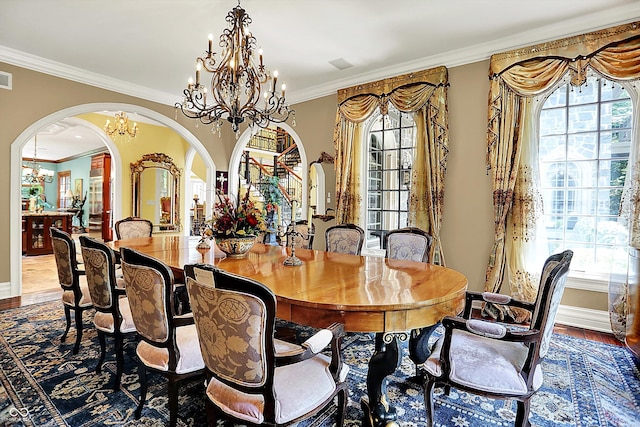 11557 Willow Springs Dr, Zionsville, IN 46077 - dining space featuring arched walkways, a chandelier, crown molding, and wood finished floors