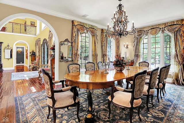 11557 Willow Springs Dr, Zionsville, IN 46077 - dining area featuring plenty of natural light, a chandelier, arched walkways, wood-type flooring, and ornamental molding