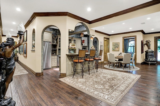 11557 Willow Springs Dr, Zionsville, IN 46077 - dining area with arched walkways, dark wood-type flooring, recessed lighting, and crown molding