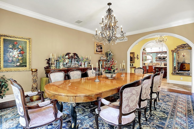 11557 Willow Springs Dr, Zionsville, IN 46077 - dining room featuring a chandelier, arched walkways, and ornamental molding