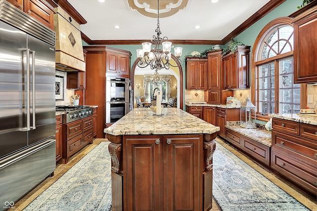 11557 Willow Springs Dr, Zionsville, IN 46077 - kitchen with stainless steel appliances, crown molding, a chandelier, custom range hood, and light stone countertops