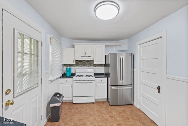 1739 Caldwell Pl, Columbus, IN 47201 - kitchen with freestanding refrigerator, white gas stove, under cabinet range hood, white cabinets, and dark countertops