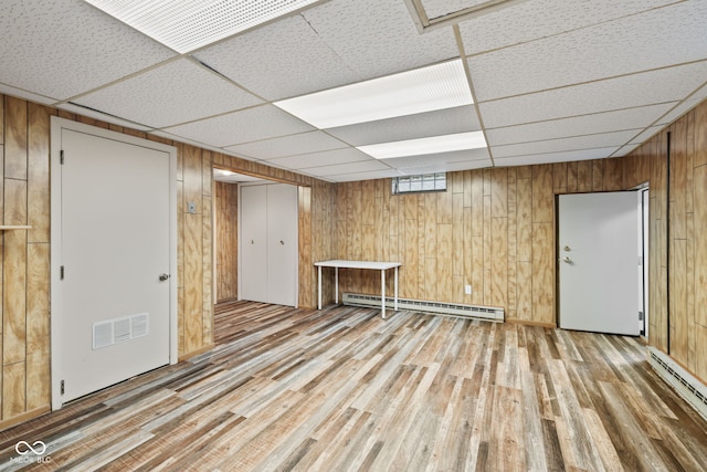 1739 Caldwell Pl, Columbus, IN 47201 - basement with a baseboard heating unit, wood walls, light wood finished floors, and a paneled ceiling