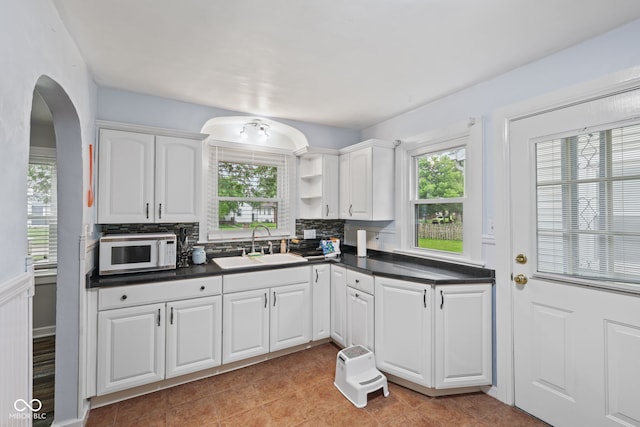 1739 Caldwell Pl, Columbus, IN 47201 - kitchen featuring white microwave, arched walkways, healthy amount of natural light, and dark countertops