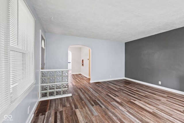 1739 Caldwell Pl, Columbus, IN 47201 - unfurnished room featuring arched walkways, wood finished floors, a textured ceiling, and plenty of natural light