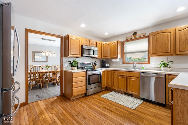 2872 N Prairie Stream Way, Columbus, IN 47203 - kitchen featuring appliances with stainless steel finishes, light wood finished floors, light countertops, recessed lighting, and a chandelier