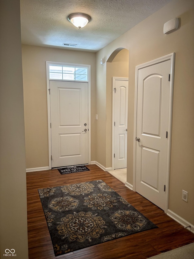 5932 Edelle Dr, Indianapolis, IN 46237 - entryway with wood finished floors, a textured ceiling, and arched walkways