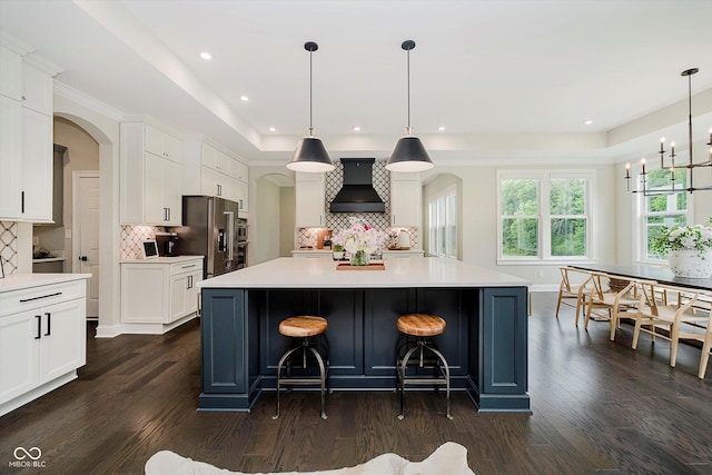5706 Bentbrook Dr, Bargersville, IN 46106 - kitchen with custom exhaust hood, stainless steel fridge with ice dispenser, arched walkways, dark wood-type flooring, and light countertops