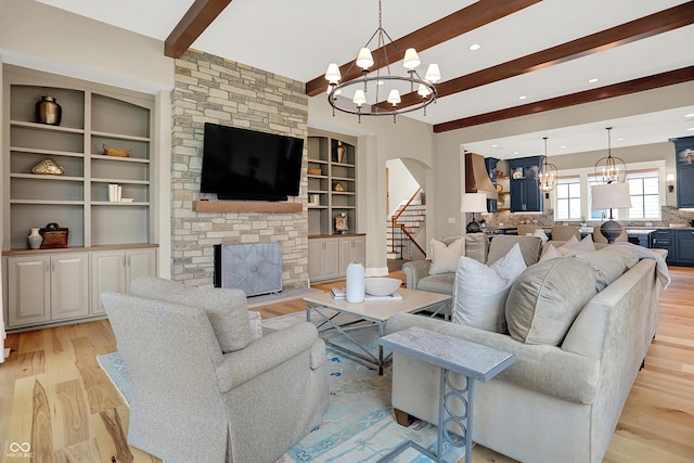 12839 Bird Cage, Carmel, IN 46032 - living area featuring a chandelier, beamed ceiling, light wood-type flooring, arched walkways, and stairway
