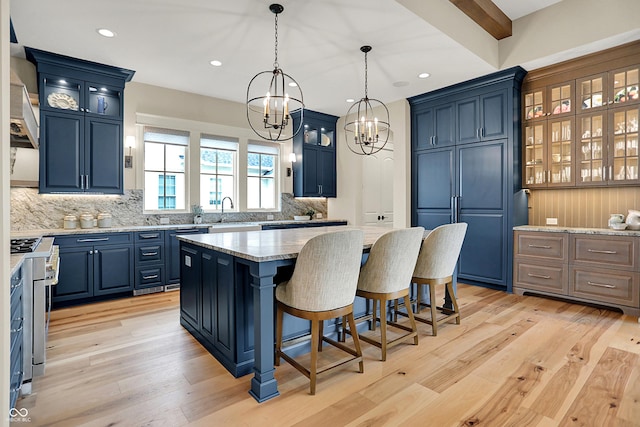12839 Bird Cage, Carmel, IN 46032 - kitchen with a chandelier, backsplash, a center island, blue cabinetry, and a breakfast bar