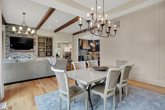 12839 Bird Cage, Carmel, IN 46032 - dining room with a chandelier, light wood-style flooring, arched walkways, beam ceiling, and built in features