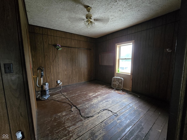 209 N Middle St, Spencer, IN 47460 - unfurnished room featuring wood-type flooring, wooden walls, a textured ceiling, and a ceiling fan