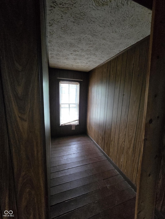 209 N Middle St, Spencer, IN 47460 - corridor featuring dark wood-style floors, wood walls, and a textured ceiling