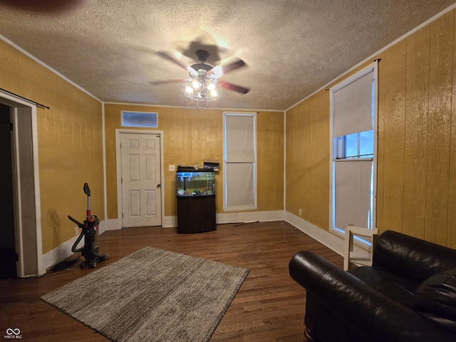209 N Middle St, Spencer, IN 47460 - living room with a ceiling fan, a textured ceiling, dark wood-style floors, wood walls, and crown molding