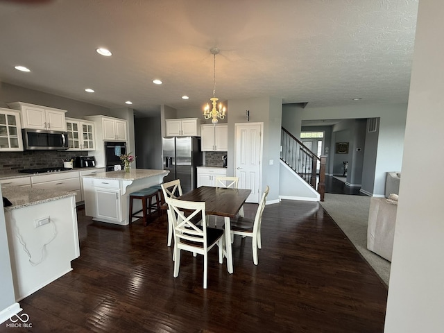 15961 Foothill Dr, Noblesville, IN 46060 - dining area featuring dark wood-type flooring, a chandelier, stairs, and recessed lighting